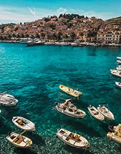 A couple sits on rocks by a serene lake